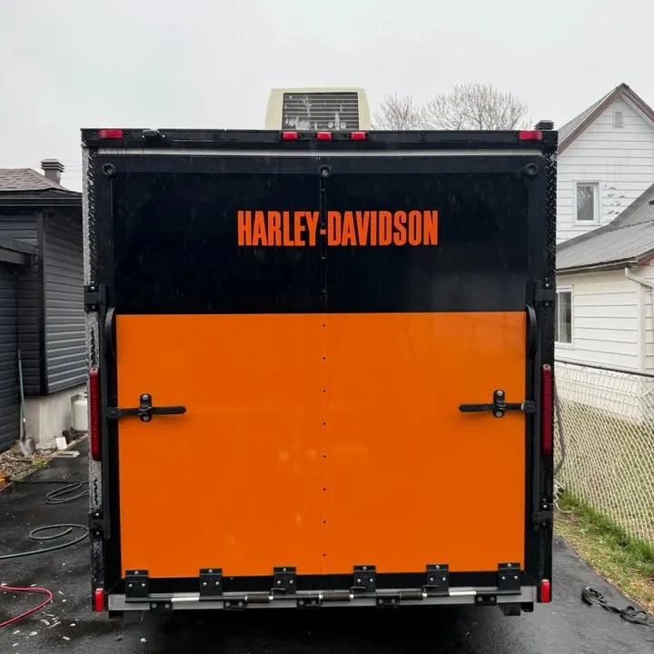 Enclosed trailer with orange vinyl covering the rear doors and Harley-Davidson lettering above